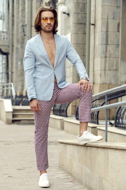 Şehirde bir yaz gününde yürüyen Modern genç adam. Tatil. Erkek güzellik, moda.