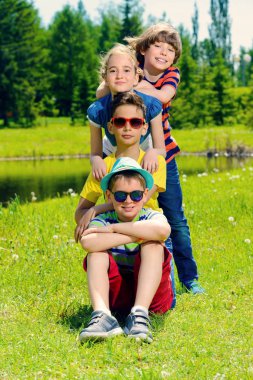 Neşeli çocuklar parkta dinlenme grubudur. Açık hava etkinliği. Yaz tatili.