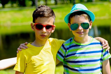 İki erkek arkadaşlarım parkta güneşli bir portresi. Yaz tatili. Dostluk.