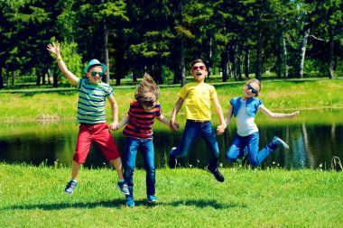 Neşeli çocuklar için parkta atlama grubudur. Açık hava etkinliği. Yaz tatili.