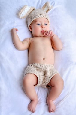 Tavşan kostüm battaniyeye yatarken şirin bebek. Aile kavramı. Paskalya tatili.