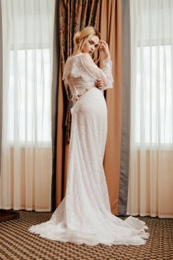 Tam uzunlukta zarif uzun elbise içinde muhteşem bir genç kadın portresi. Lüks daireler. Düğün moda.