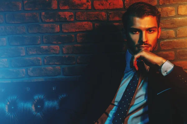 Şık elbiseli klasik lüks iç dairelerinde oturan saygın yakışıklı adam. Erkek güzelliği, moda.