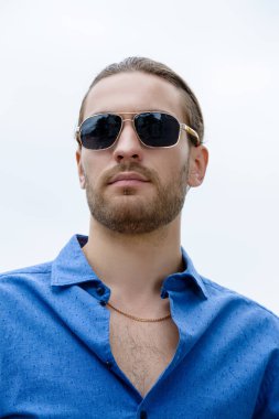 Kot pantolon giysili yakışıklı genç bir şehir sokak üzerinde duruyor. Erkek moda.