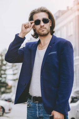 Kot pantolon ve ceket bir şehir sokak yakışıklı genç adam. Erkek güzelliği, moda. Aktif yaşam tarzı.