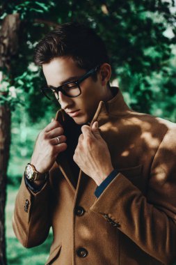 İş kıyafetleri bir yaz parkta poz zarif bir genç adam portresi. Açık moda. İş tarzı. 