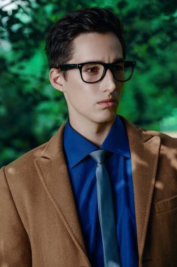 İş kıyafetleri bir yaz parkta poz zarif bir genç adam portresi. Açık moda. İş tarzı. 