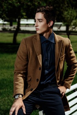 Bir yaz parkta şık giysiler içinde poz zarif genç adam. Açık moda. İş tarzı. 