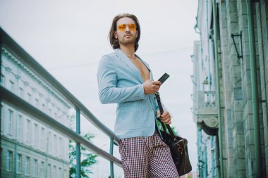 Erkek moda. Yakışıklı Modern bir şehir cep telefonuyla konuşurken sokak. Yaz günü. 