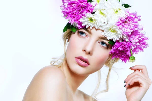 Portrait of a sensual spring lady in a wreath of flowers. Beauty, cosmetics. Make-up. White background. Copy space.