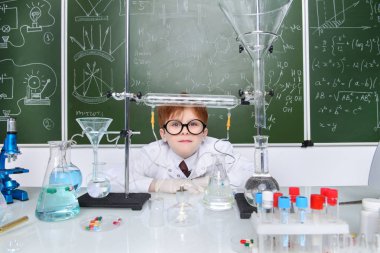 Zeki öğrenci tarafından bir kara tahta kimya dersi üzerinde duruyor. Eğitim kavramı.