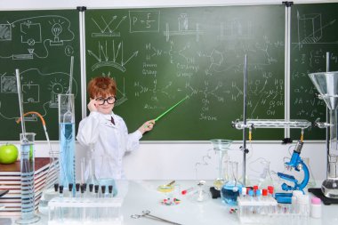 Zeki öğrenci tarafından bir kara tahta kimya dersi üzerinde duruyor. Eğitim kavramı.