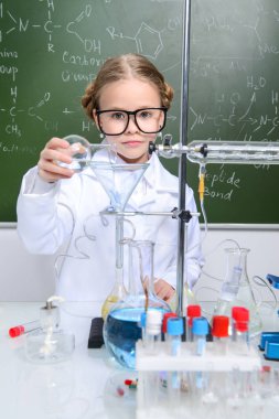 Ciddi küçük kız laboratuvarda deneyler yapıyor. Bilim ve eğitim.