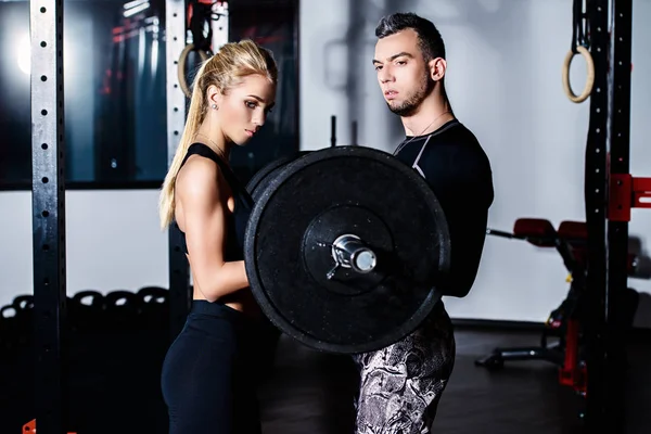 Kas gençlerle bir spor salonunda güzel atletik organları portresi. Fitness, vücut geliştirme. Sağlık.
