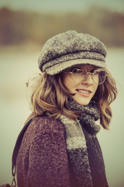 Sevimli genç kız açık poz modern giysiler içinde. Sıcak sonbahar günü. Mevsim sonbahar ve Kış moda.