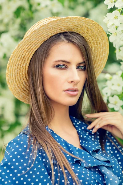 Bir çiçek bahçesinde poz hasır şapkalı güzel kız. Güzellik, moda.