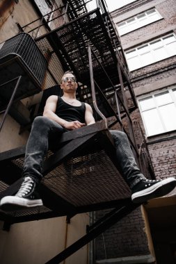 Bir punk adam sokakta portresi. Adam arka bahçesinde. Moda, alt kültür.