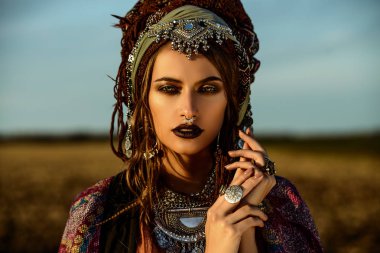 Güzel moda model güneşin ışınları boho tarzı giysilerle poz. Açık moda.