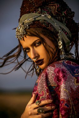 Güzel moda model güneşin ışınları boho tarzı giysilerle poz. Açık moda.