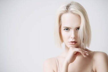 Beyaz arka plan üzerinde çıplak makyaj güzel bir sarışın kadınla yakın çekim portre. Güzellik, moda kavramı. Kalıcı makyaj ve kozmetik. Kısa saçlar için saç kesimi.