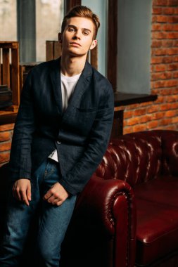 Deri kanepede poz şık giysileriyle akıllı öğrenci çocuk. Moda. Eğitim kavramı.