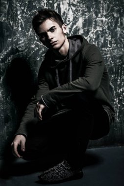 Grunge arka plan üzerinde bir genç çocuk portresi. Stüdyo vurdu. Genç moda.