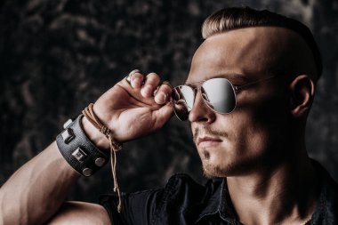 Stüdyoda güneş gözlüğü takıyor bir hipster adam portresi.