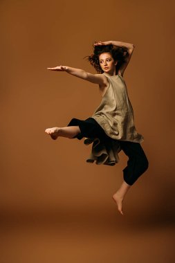 Uzun kıvırcık kırmızı saçlı modern on beş yaşındaki kız stüdyoda dans ediyor. Güzellik, moda. Vogue dans.