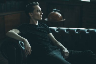 Dalgın, yakışıklı bir genç adam bir odada portresi. Erkek güzellik ve sağlık.