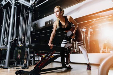 Bir spor salonunda çalışan güzel atletik genç kadın. Sağlıklı bir yaşam tarzı. Spor, fitness, vücut geliştirme.