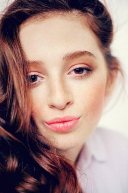 Yakın çekim beyaz arka plan üzerinde uzun kıvırcık kırmızı saçlı bir on beş yaşındaki kız portresi. Güzellik, moda.