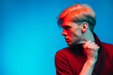 Yakın çekim portre sarışın saç stüdyoda ışık arka plan üzerinde poz ile yakışıklı bir genç adam. Erkek güzellik ve sağlık.