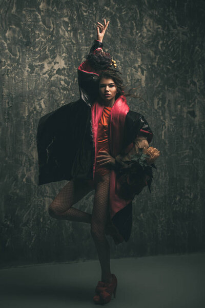 Female beauty, fashion. Full length portrait of a female model posing in stylish clothes. Studio shot over grunge background.