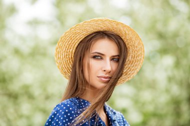 Bir çiçek bahçesinde poz hasır şapkalı güzel kız. Güzellik, moda.