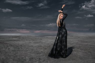 Tam uzunlukta portre güzel bir Gotik kadının uzun siyah elbise poz açık. Güzellik, moda.