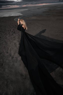 Tam uzunlukta portre güzel bir Gotik kadının uzun siyah elbise poz açık. Güzellik, moda.