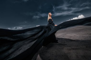 Tam uzunlukta portre güzel bir Gotik kadının uzun siyah elbise poz açık. Güzellik, moda.