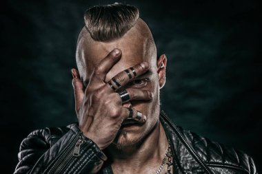 Adam cvering yakın çekim portre yüzünü bir palm ile. Siyah arka plan. Deri ceket.