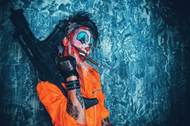 Deli şeytani palyaço adam kan lekeli bir puro sigara ve elinde bir silah. Cadılar Bayramı. Korku, gerilim filmi.