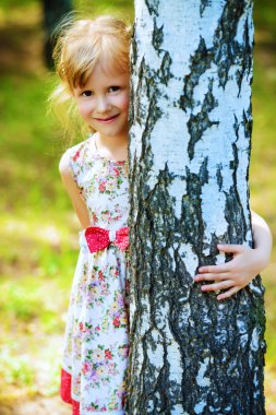 Sevimli küçük kız yaz Park'ta yürüyordunuz. Güneşli gün.