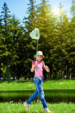 Bir kelebek ağı ile neşeli kız bahçede güneşli yaz günü çalışır..