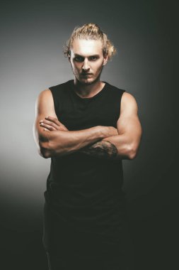 Grunge arka plan üzerinde poz yakışıklı atletik erkek portresi. Kentsel tarzı.