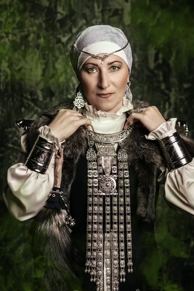 Portrait of an elderly native woman. A national costume. Mature lady.