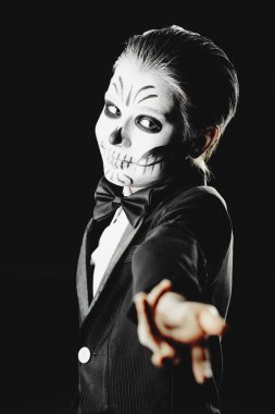 Bir çocuk çocuk portresi zarif kuyruk-ceket giyen bir iskeletin karnaval makyajlı. Studio siyah arka plan üzerinde vurdu. Cadılar Bayramı. Dia de los muertos. Ölülerin günü.