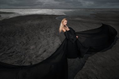 Tam uzunlukta portre güzel bir Gotik kadının uzun siyah elbise poz açık. Güzellik, moda.