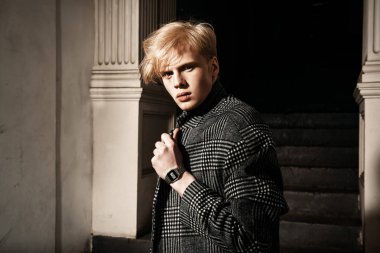 Sarı saçlı bir şehir sokakta duran bir ekose ceket giyiyor ile yakışıklı bir genç adam portresi. Erkek güzellik ve sağlık. Güzellik, şehir moda.