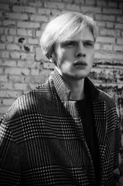 Sarı saçlı bir şehir sokakta duran bir ekose ceket giyiyor ile yakışıklı bir genç adam portresi. Erkek güzellik ve sağlık. Güzellik, şehir moda.