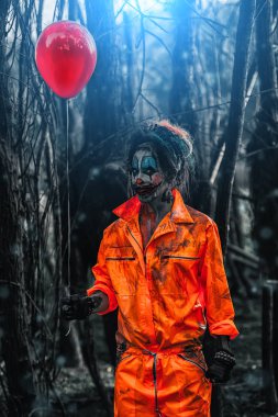 Korkunç adam palyaço balon ile bir gece ormanda kan lekeli. Erkek zombi palyaço. Cadılar Bayramı. Korku.