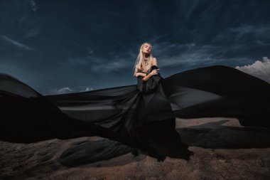 Tam uzunlukta portre güzel bir Gotik kadının uzun siyah elbise poz açık. Güzellik, moda.