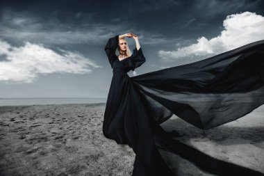 Tam uzunlukta portre güzel bir Gotik kadının uzun siyah elbise poz açık. Güzellik, moda.